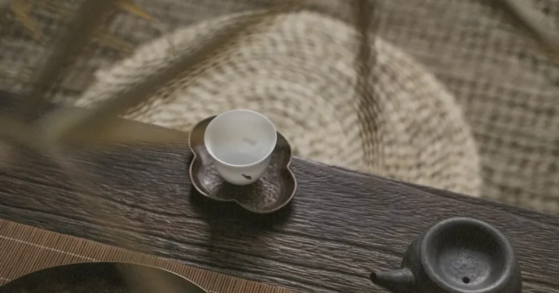 white teacup on saucer near teapot