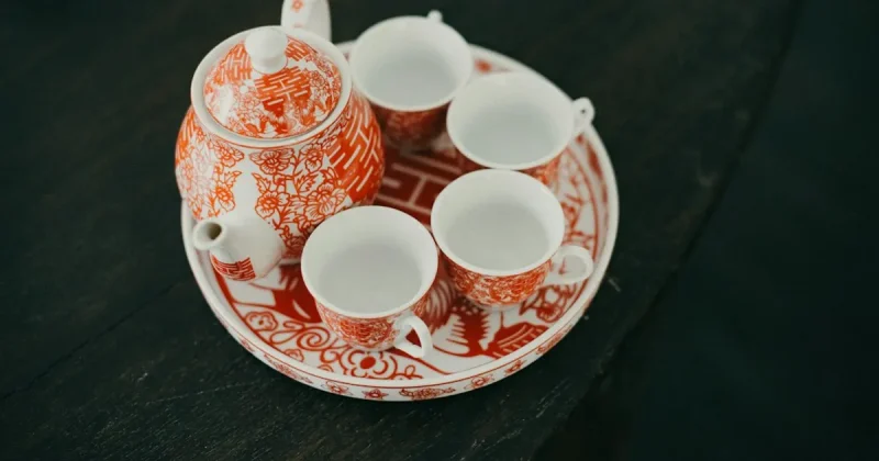 A red and white tea set on a wooden table