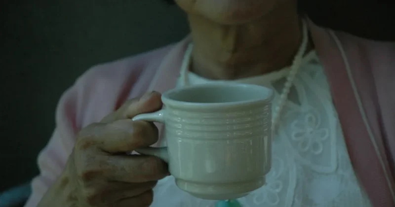 woman holding white cup
