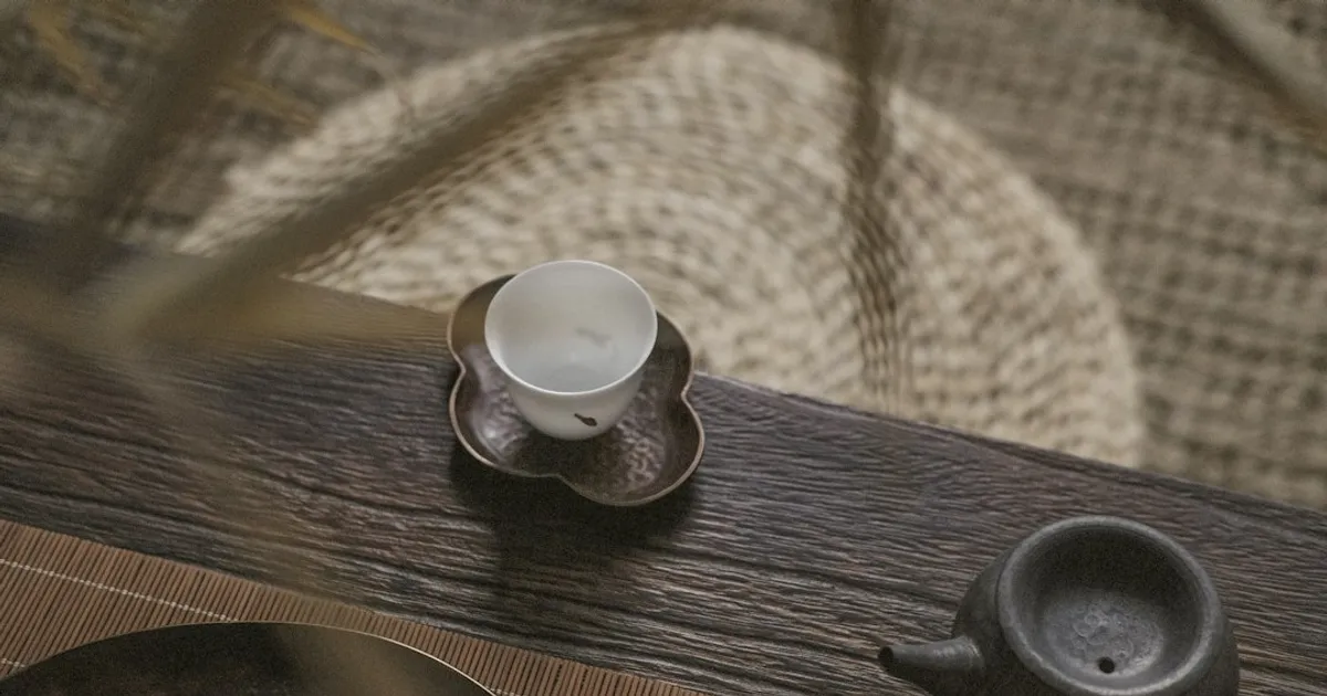 white teacup on saucer near teapot